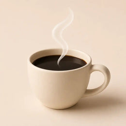 Taza de café negro vista desde arriba sobre una mesa de madera
