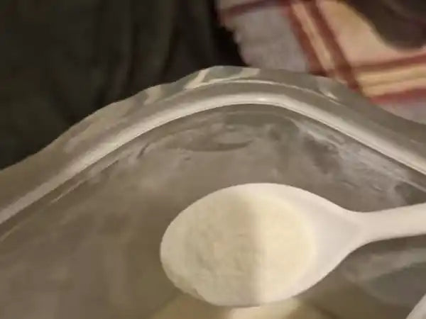 Cuchara medidora con el colágeno en polvo sobre la bolsa abierta